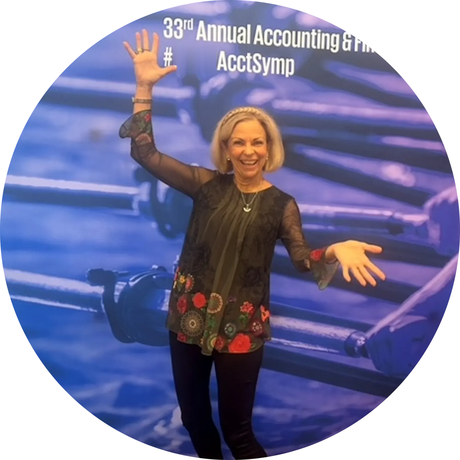 Amanda Gore, leadership keynote speaker, smiling with her arms out wide on a conference stage