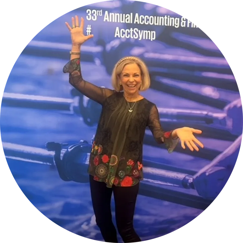 Amanda Gore, leadership speaker, smiling with her arms out wide on a conference stage