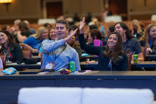 Two audience members giving each other a high five at an Amanda Gore keynote