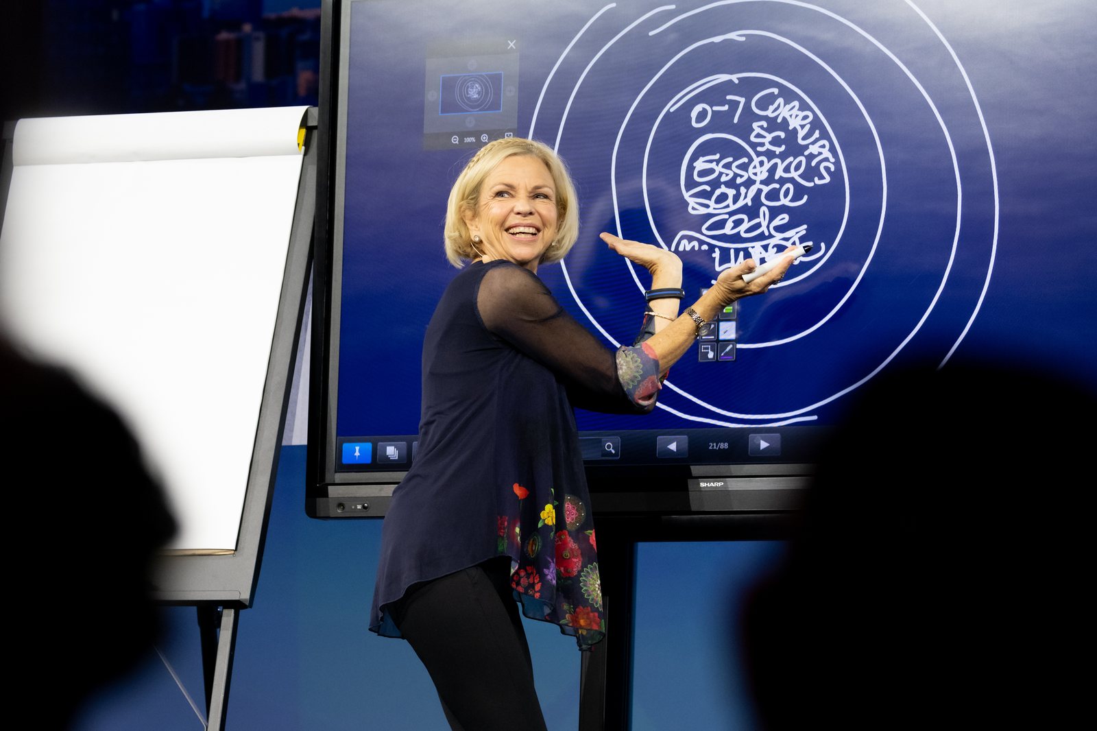 Amanda Gore, leadership keynote speaker, drawing on a big screen on stage