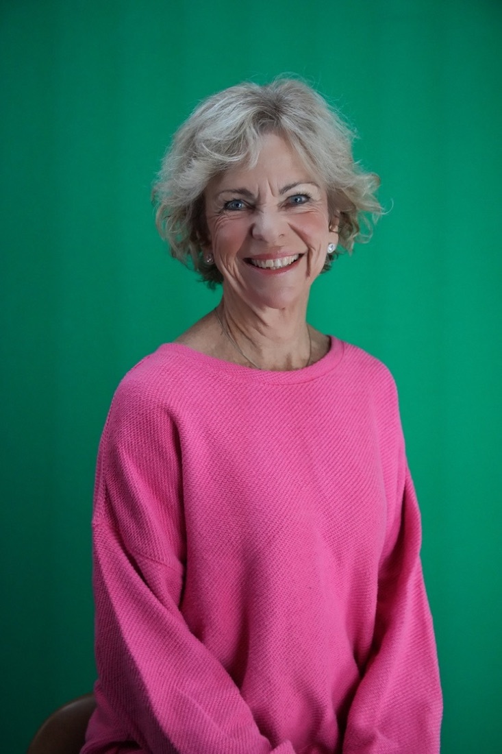 Amanda Gore, leadership keynote speaker, smiling in a pink sweater