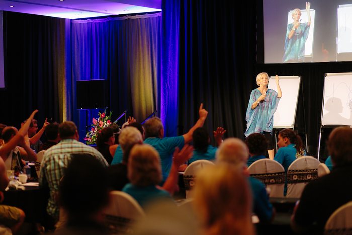 Amanda Gore on stage with the audience seen from behind