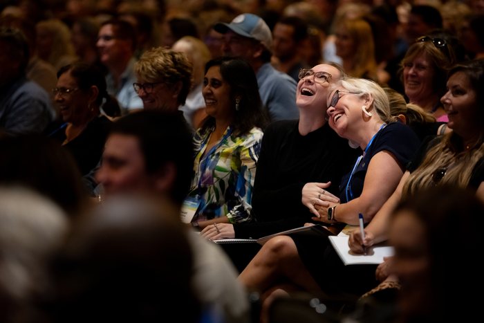 Audience members laughing together at an Amanda Gore keynote